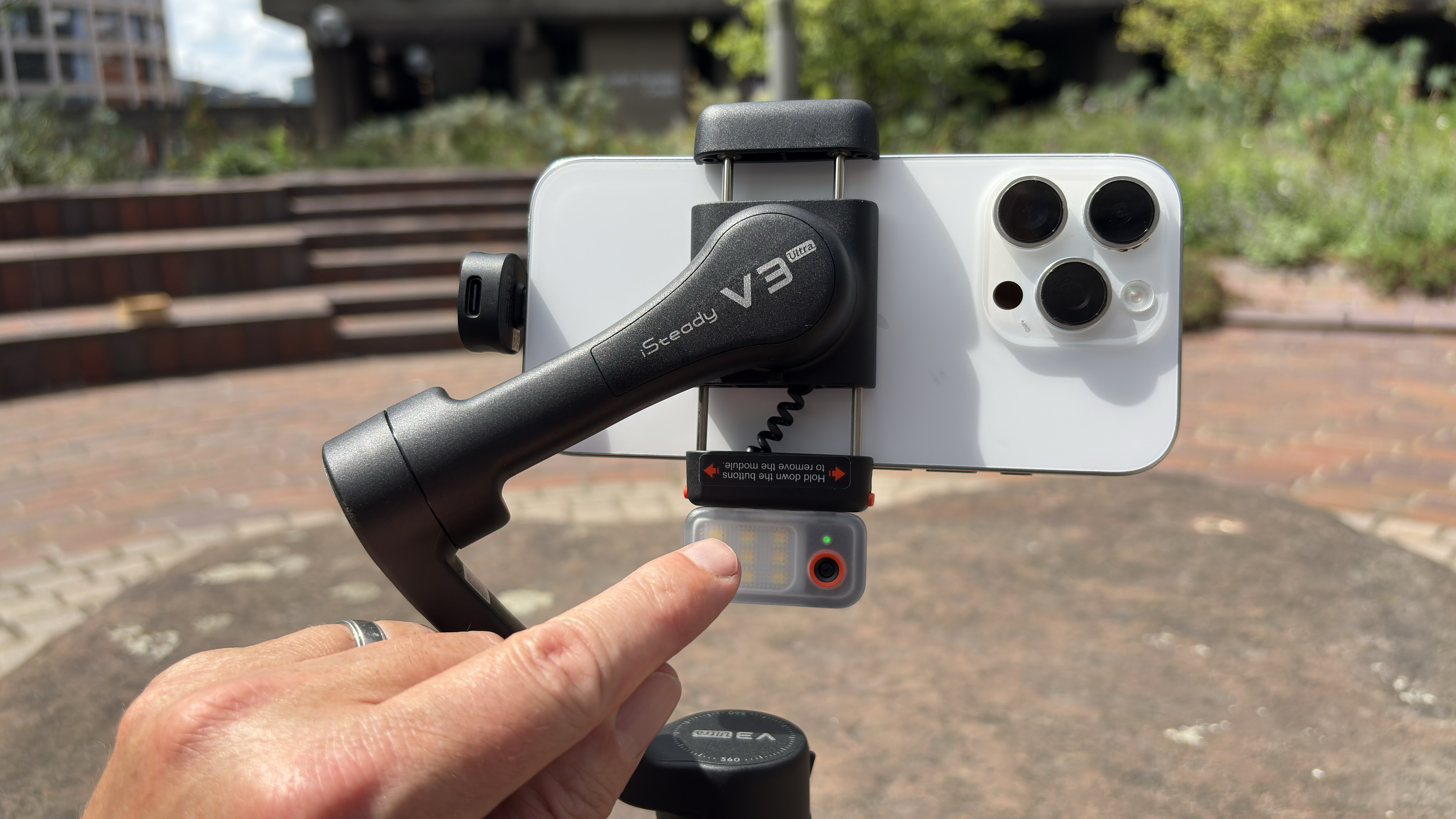Shot of finger pointing at the AI tracking module clipped to the front of the stabiliser.