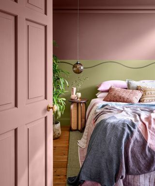 pink and green bedroom with a painted wave line above the bed