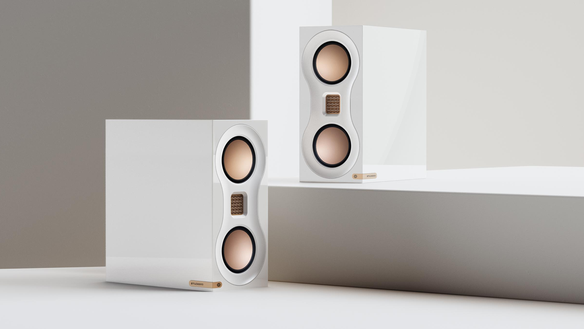 Monitor Audio Studio 89 speakers in high gloss white in a studio against white and grey surfaces