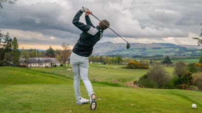 Golfer holds their finish view from behind