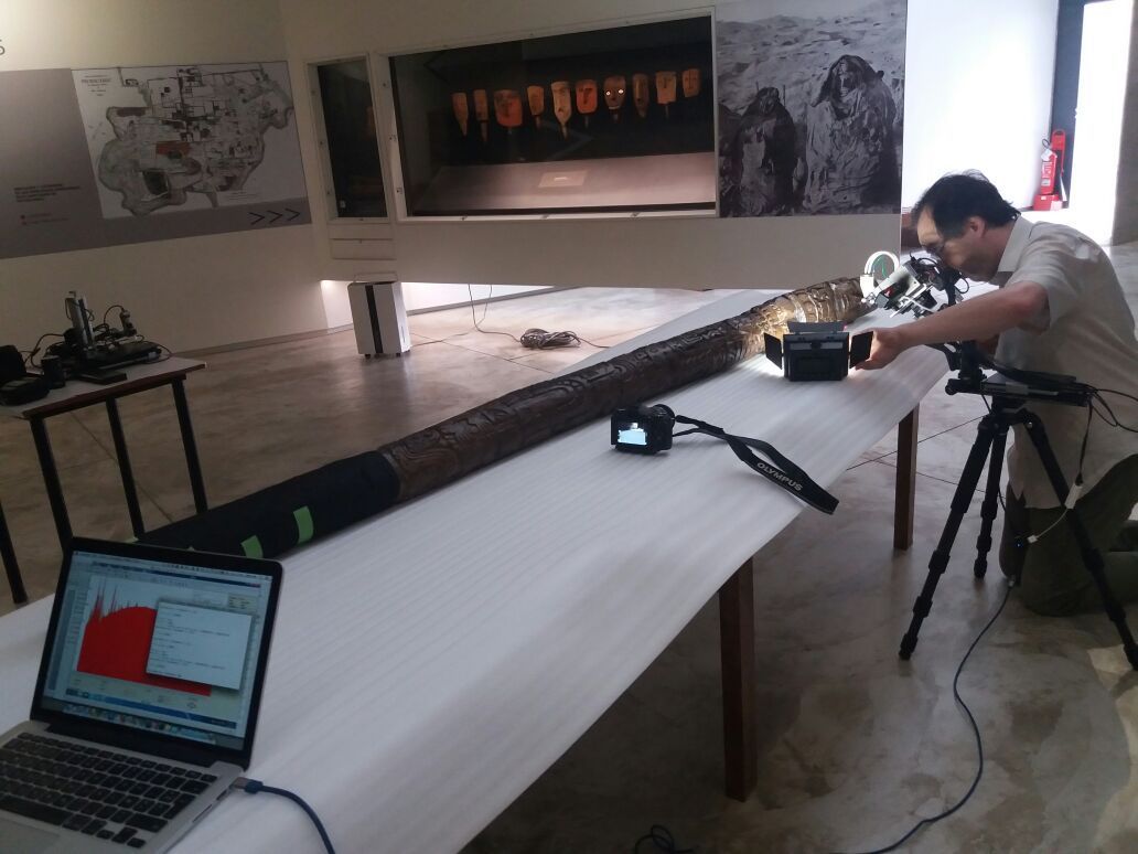 A researcher examines the 7.6-foot-long (2.34 meters) idol in the lab.