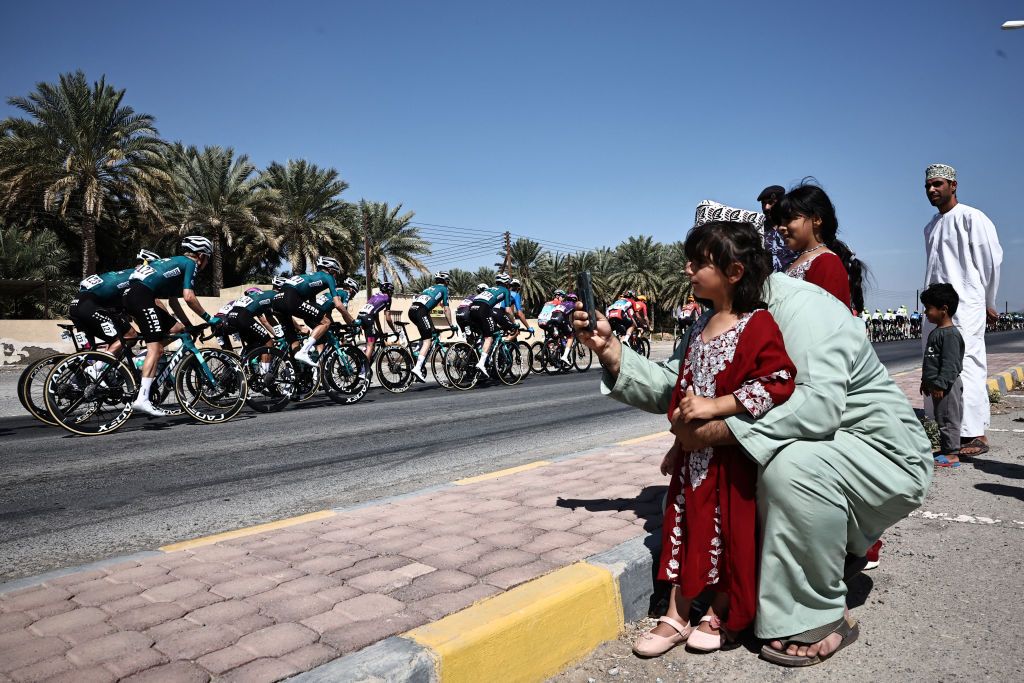 Spectators watch from the roadside as the pack rides during the first stage of the Tour of Oman between the Oman Across Ages Museum and the Oman Convention and Exhibition Centre in Muscat