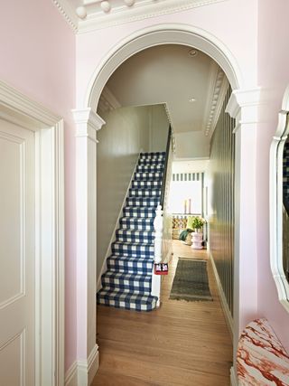 A small hallway with an arch painted pink