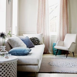 living room with white walls and pillows on couch