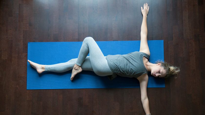 woman doing supine twist on mat 