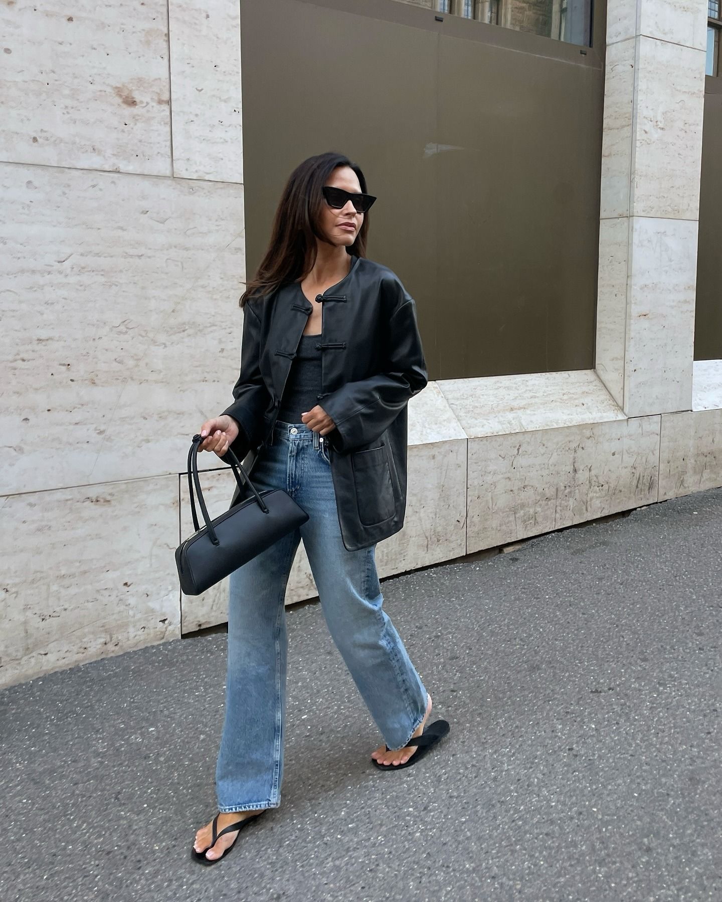 Photo of influencer wearing black leather collarless jacket.