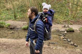 Man hiking with baby in backpack-style carrier