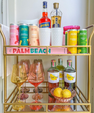 A colorful bar cart with Aperol and citrus drinks