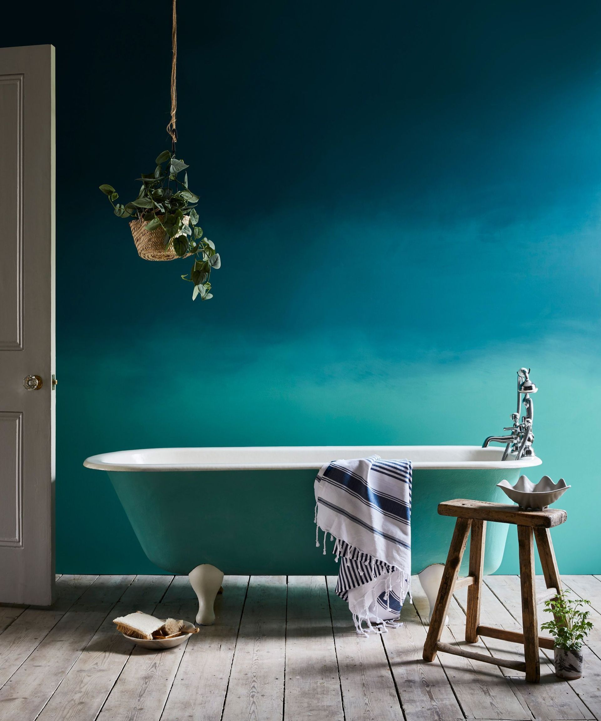 A bathroom with a wall painted blue in an ombre effect