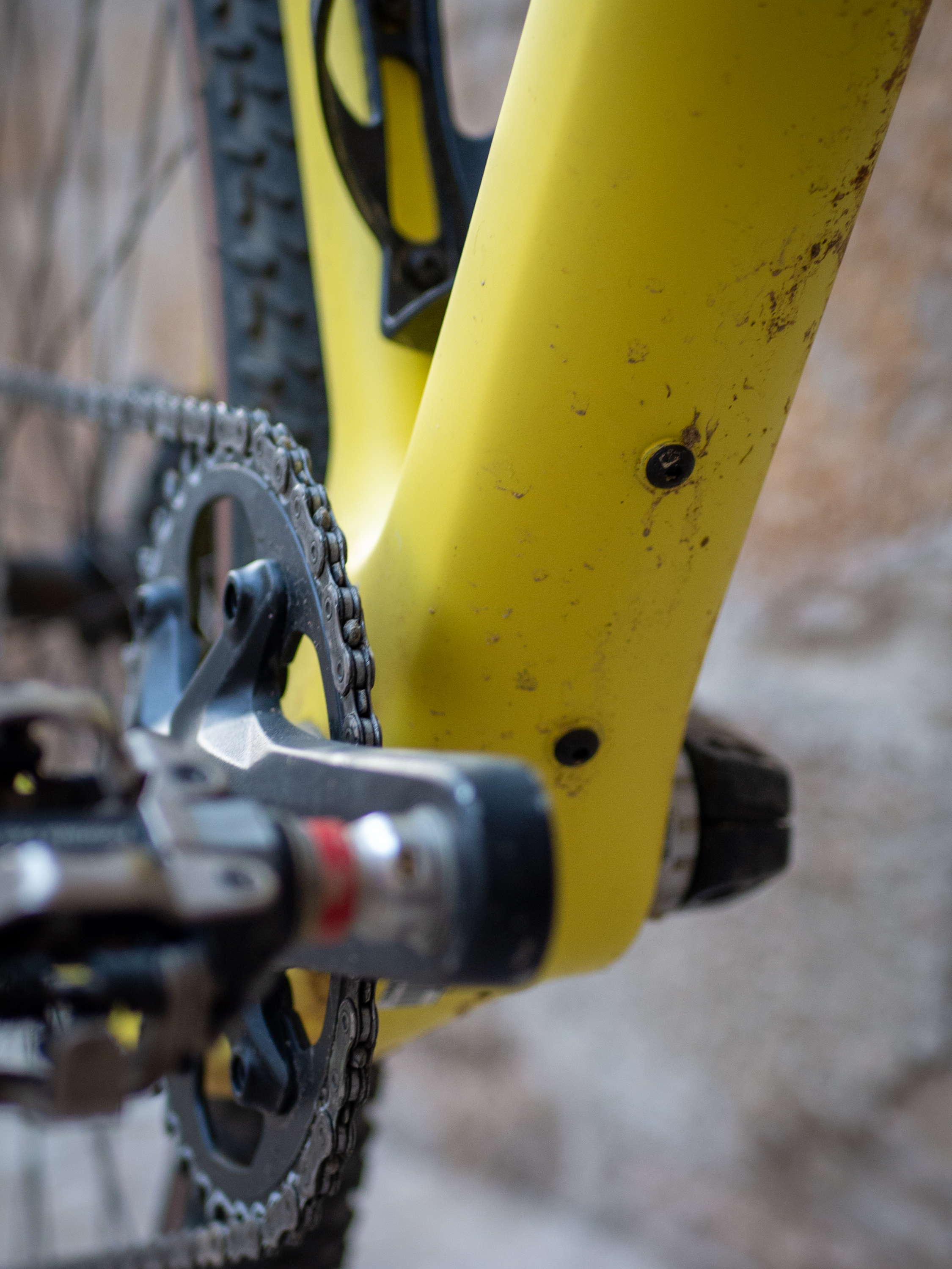 A yellow Guava Spot gravel bike leans against a wall