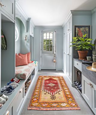 mud room with gray cabinets and bright vintage style rug