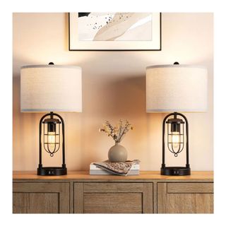 set of two tamble lamps with white shades on wood console table