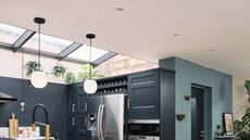 A blue kitchen with light ceiling and skylights