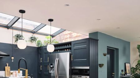 A blue kitchen with light ceiling and skylights