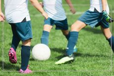 Close up of children's feet as they play football