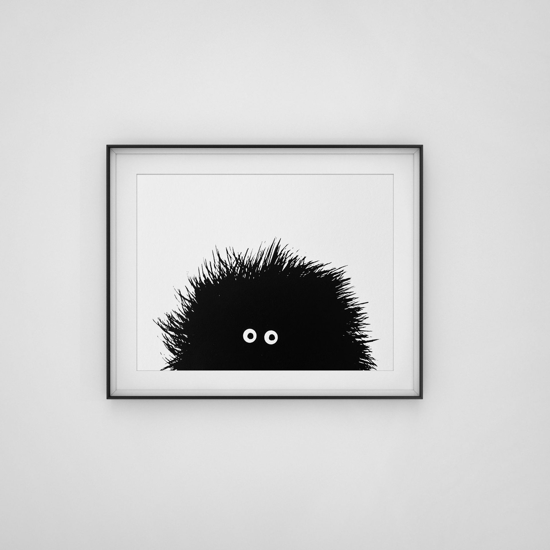 Black framed screenprint of black hairy creature with big eyes