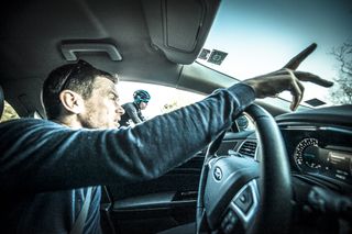Head of Athletic performance Tim Kerrison jestures to 3 time Tour de France winner Chris Froome from the team car