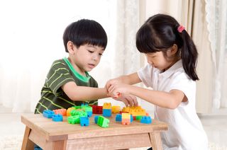 Two kids play with toys together.