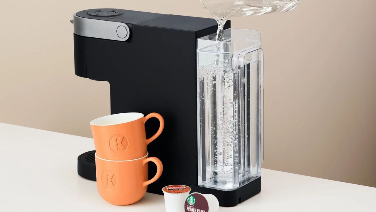 Keurig K Slim Iced coffee maker with teacups, pods, and a filled reservoir