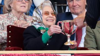 Queen Elizabeth II receives the winners cup at The Royal Windsor Horse Show at Home Park on May 13, 2022 in Windsor