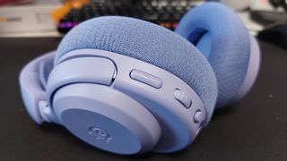 The SteelSeries Arctis Nova 3 X seen on a desk. This is the Lavender colourway.