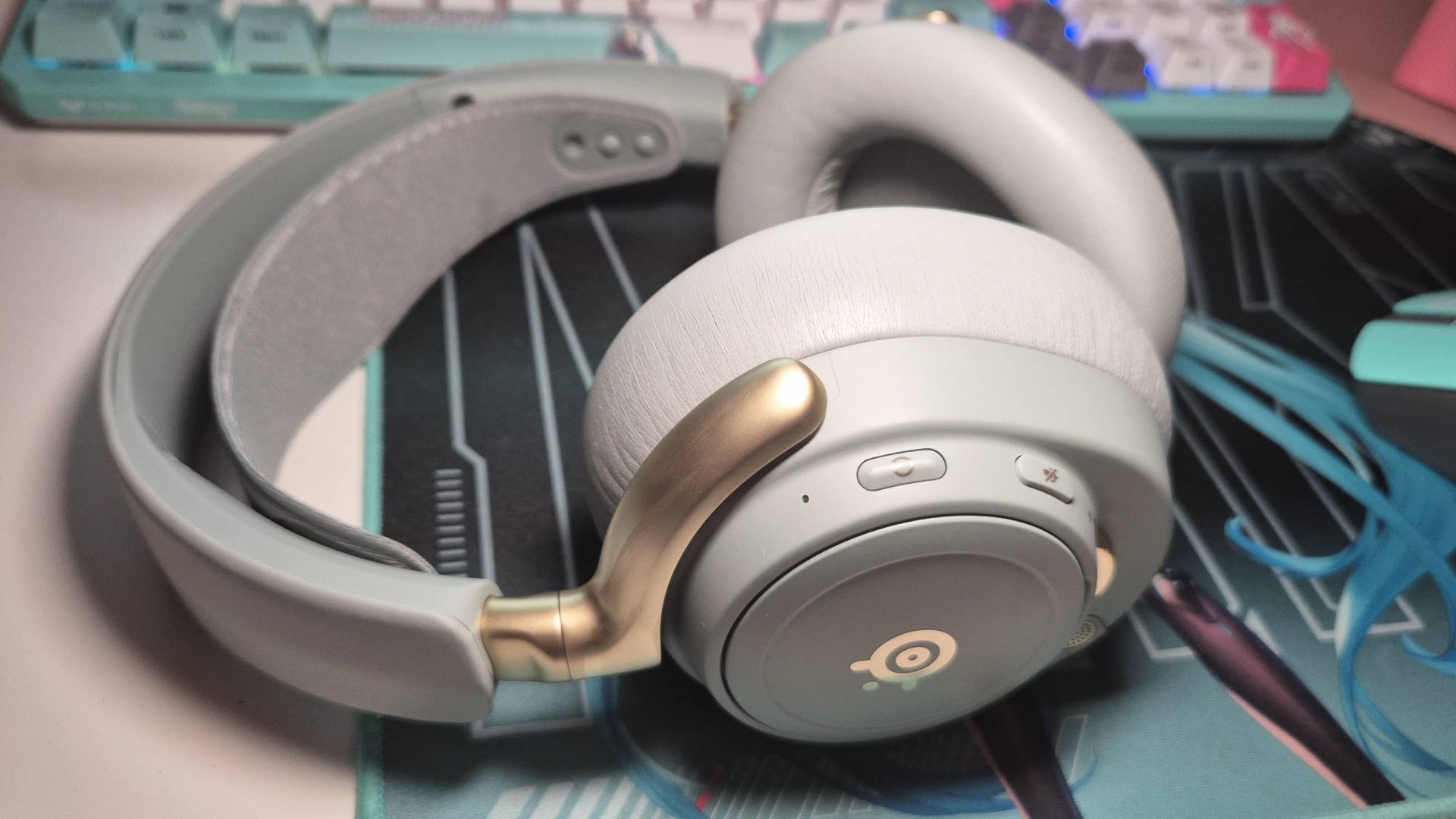 Photo of the SteelSeries Arctis Nova Elite headset resting on some Hatsune Miku PC accessories.