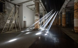 Beams of light hit the floor of the gallery