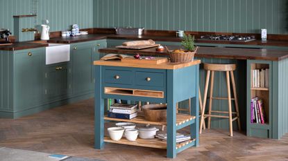 small green kitchen with small blue kitchen island