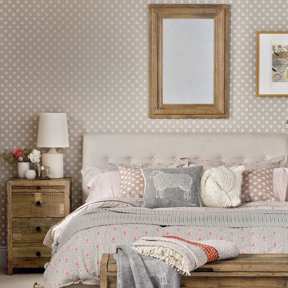 Small bedroom with polka dot wallpaper double bed and wooden side table