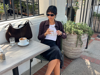 Stephanie Arant in a tank top and slip skirt with a brown suede bag.