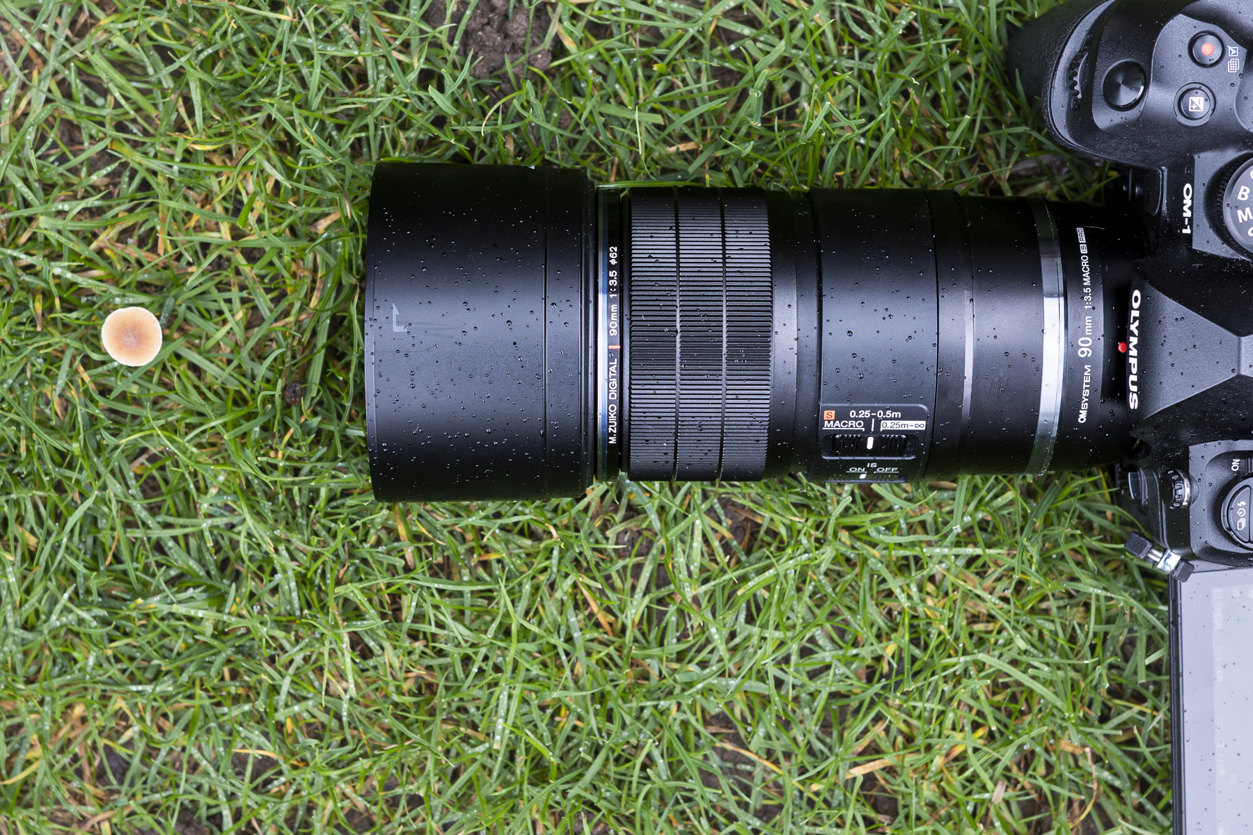 OM System 90mm macro lens on the ground from above attached to the OM-1 camera