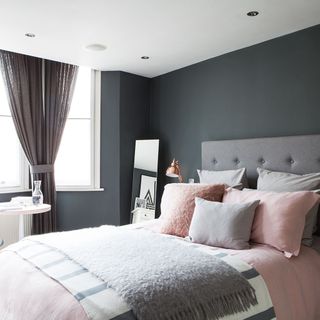 guest room with grey wall and grey curtains and mirror