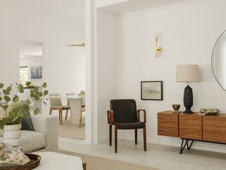 living room with mid century modern furniture, white walls, stone floor, view into dining space