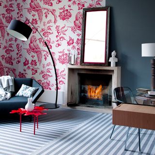 living room with blue sofaset and red floral printed walls