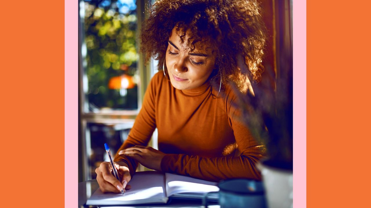 What is a serendipity journal? Pictured: Portrait of cute mixed race student with curly hair and in turtleneck sitting in cafe and writing