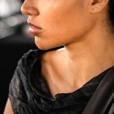 Woman backstage with a toned jawline turning to the side 