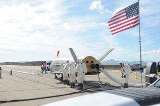 An American flag waves over the runway landing site for the U.S. Air Force's third X-37B space plane mission, which returned to Earth on Oct. 17, 2014 after a 22-month secret mission.