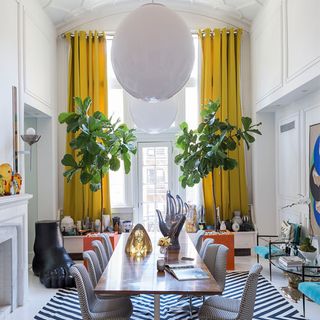 white walls dinning table with chair and yellow curtains with trees