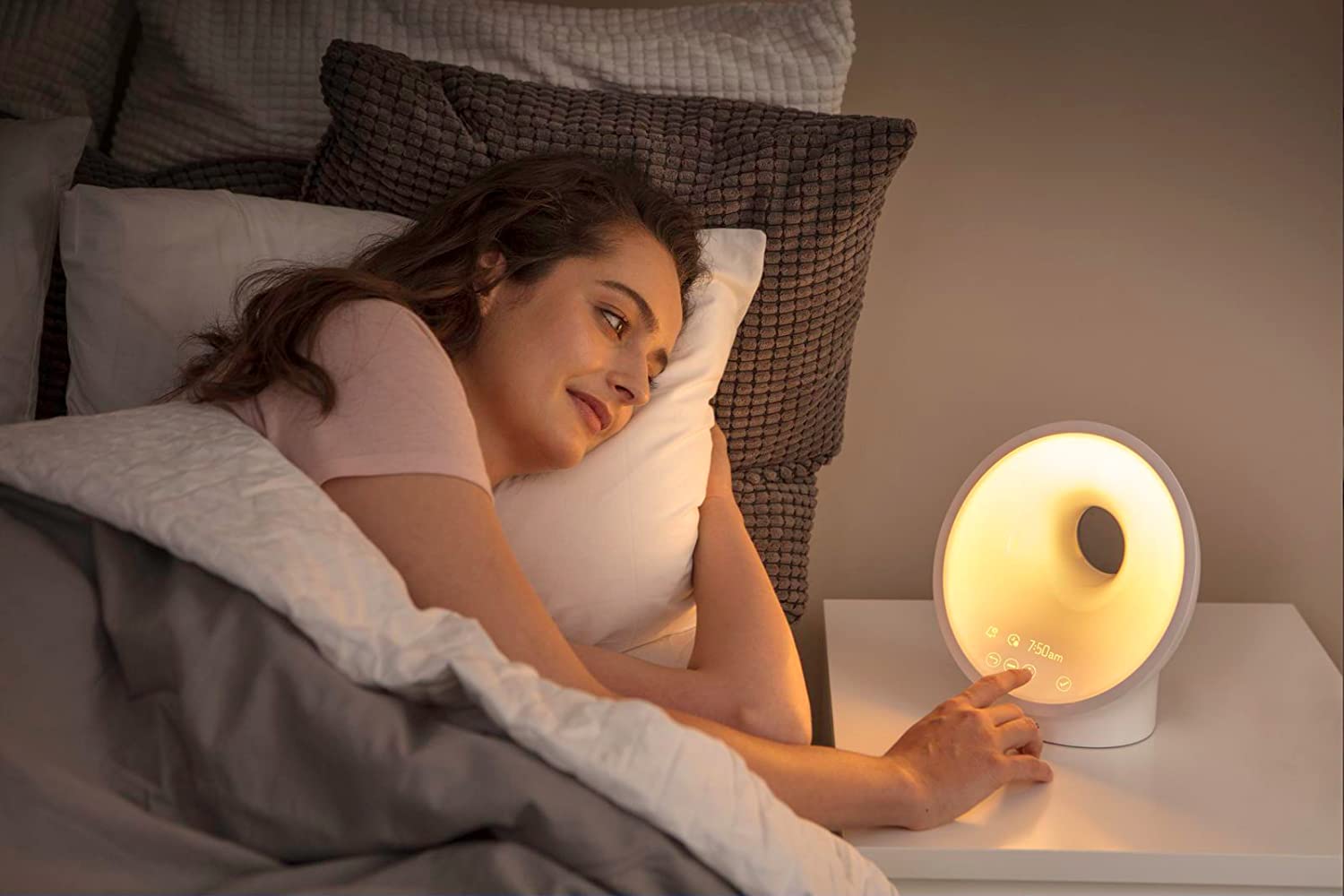 Woman in bed with Fitfort light on her bedside table