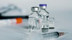 vials of clear liquid on table with syringe