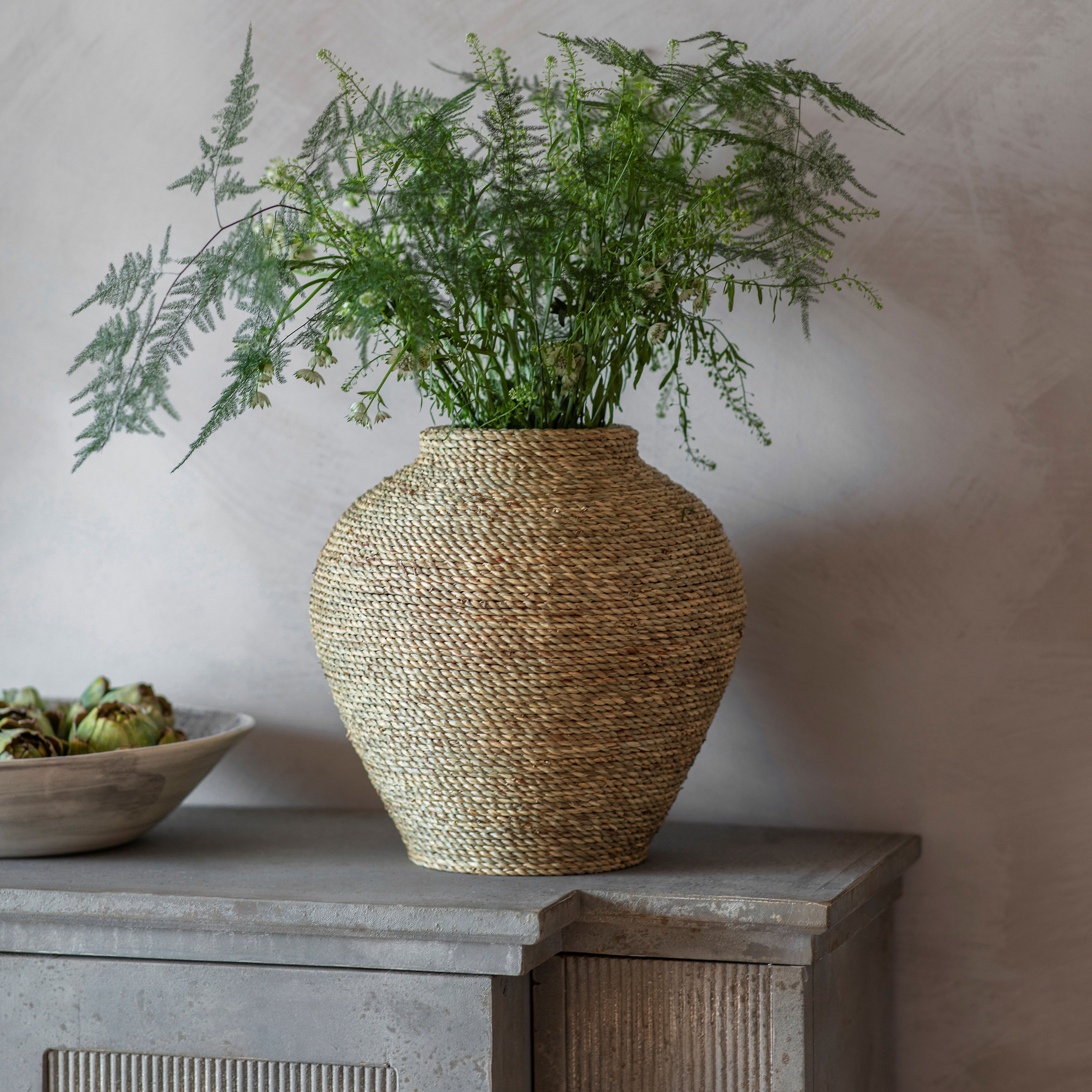 Rattan vase with greenery inside