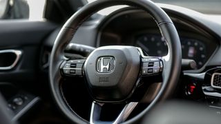 2025 Honda Civic Sport Touring Hybrid steering wheel closeup.