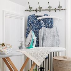 Steam iron placed on top of ironing board with tea towels
