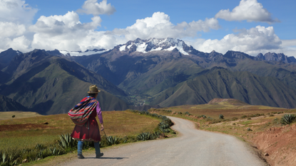 A man walking along a road through the Andes