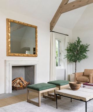 neutral living room with a stone fireplace and a giant mirror on the mantel as a disguised TV