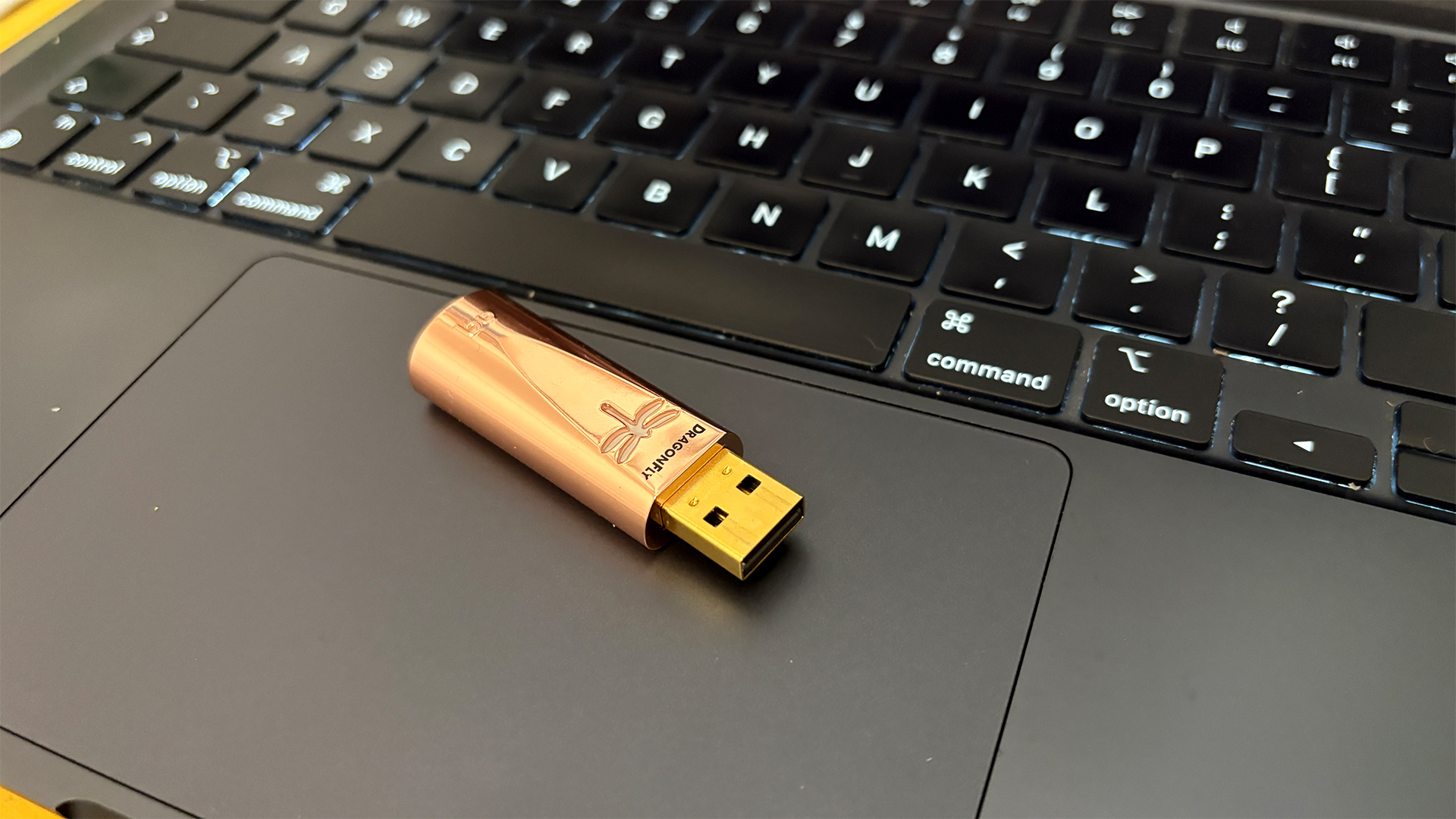 AudioQuest DragonFly Copper DAC sitting on laptop trackpad