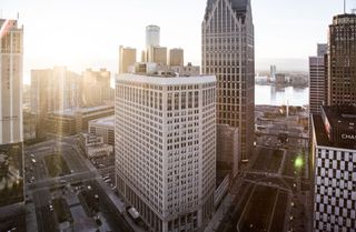 Downtown Detroit from the rooftop of 1001 Woodward during sunrise. From left to right: The First National building, Renaissance Center, One/Ally Detroit Center, Woodward Avenue, the Detroit River, Har
