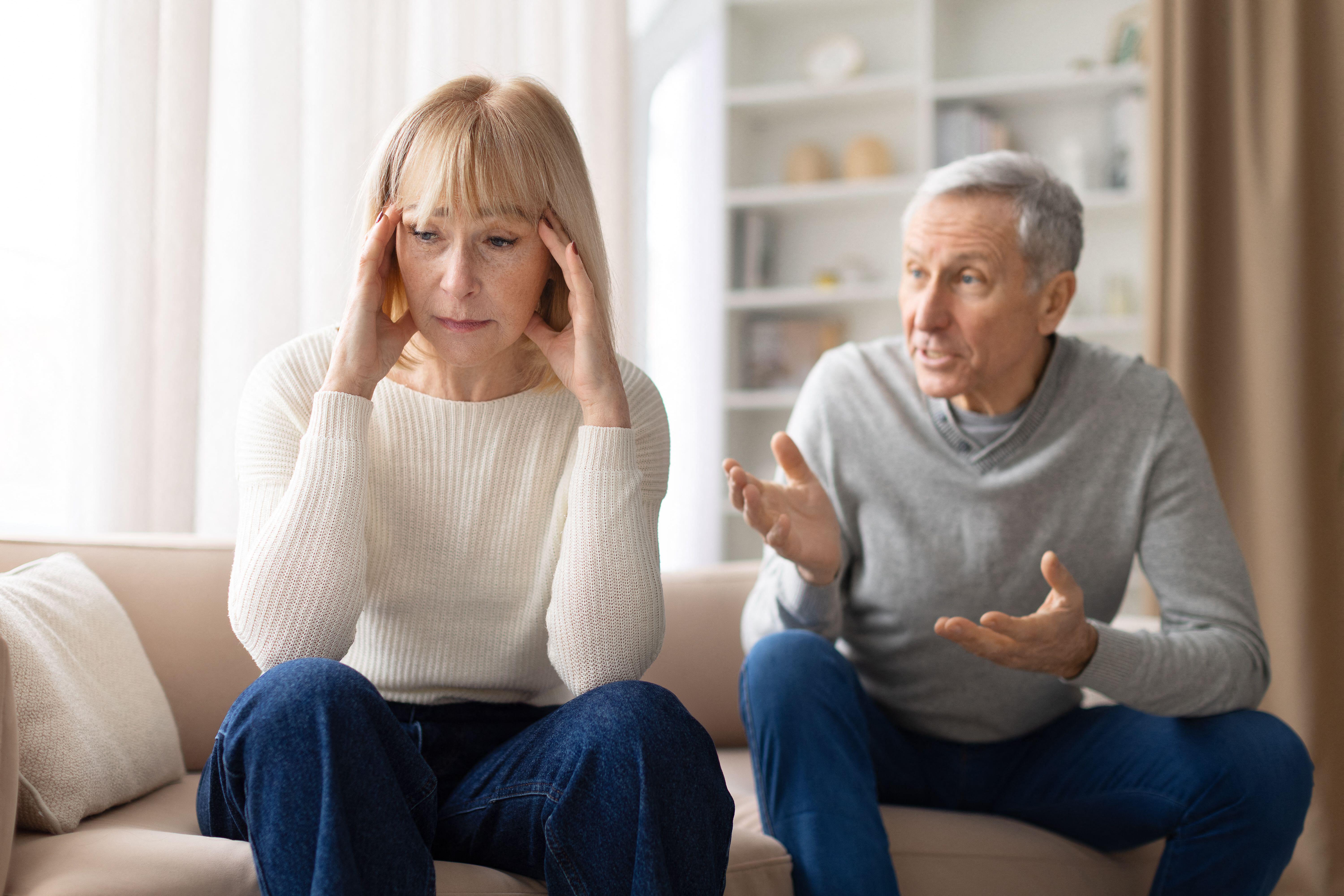 3EEGJ1P Stressed senior woman sitting on sofa during argument with husband at home