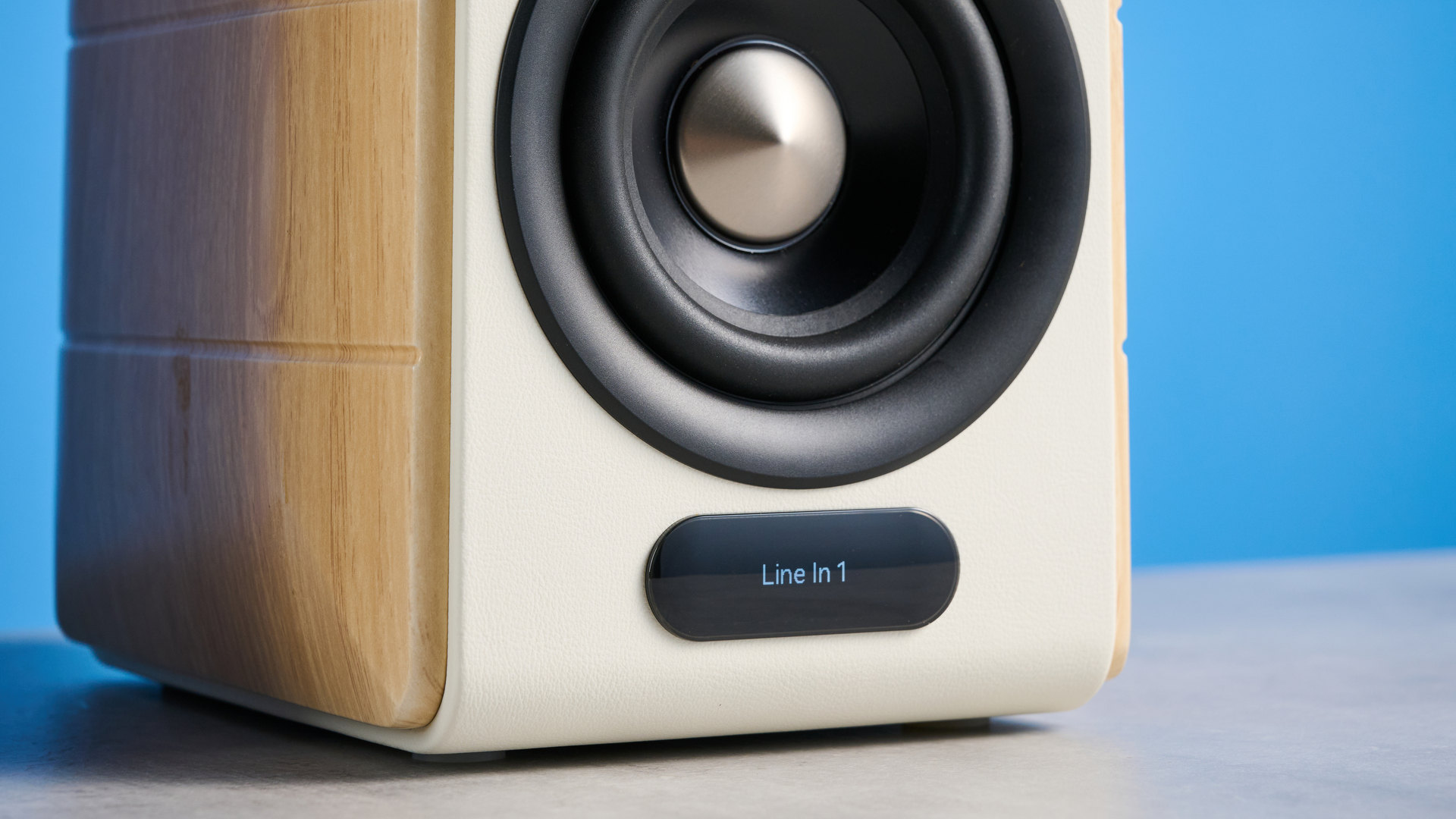 the edifier s880db mkii speakers in white and wood colorway showing the connectivity options, remote control, against a blue background