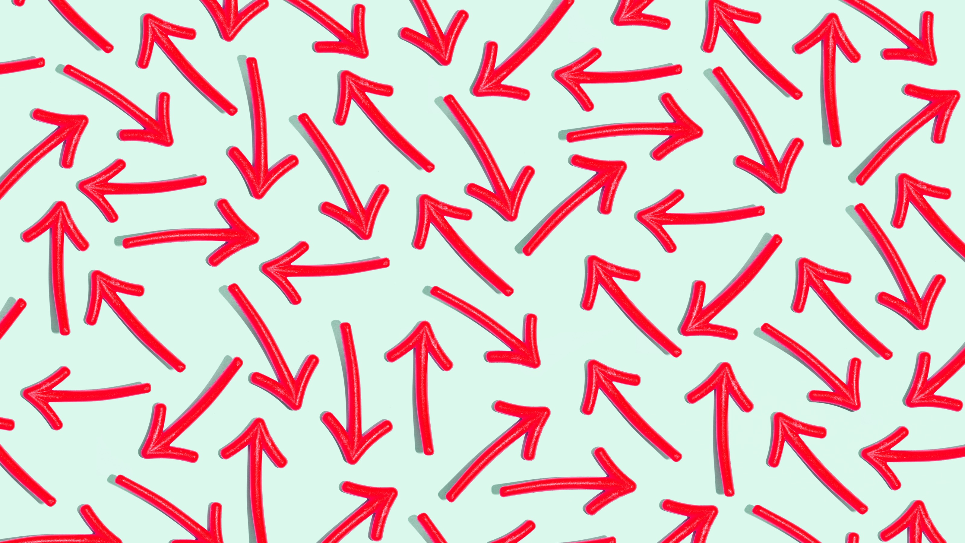 Multiple red arrows pointing every which way on a light green background.